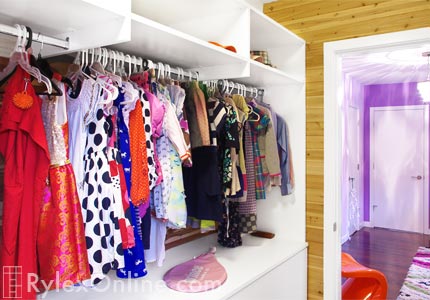 Girl's White Walk-In Closet with Continuous Hanging Space and Open Shelves