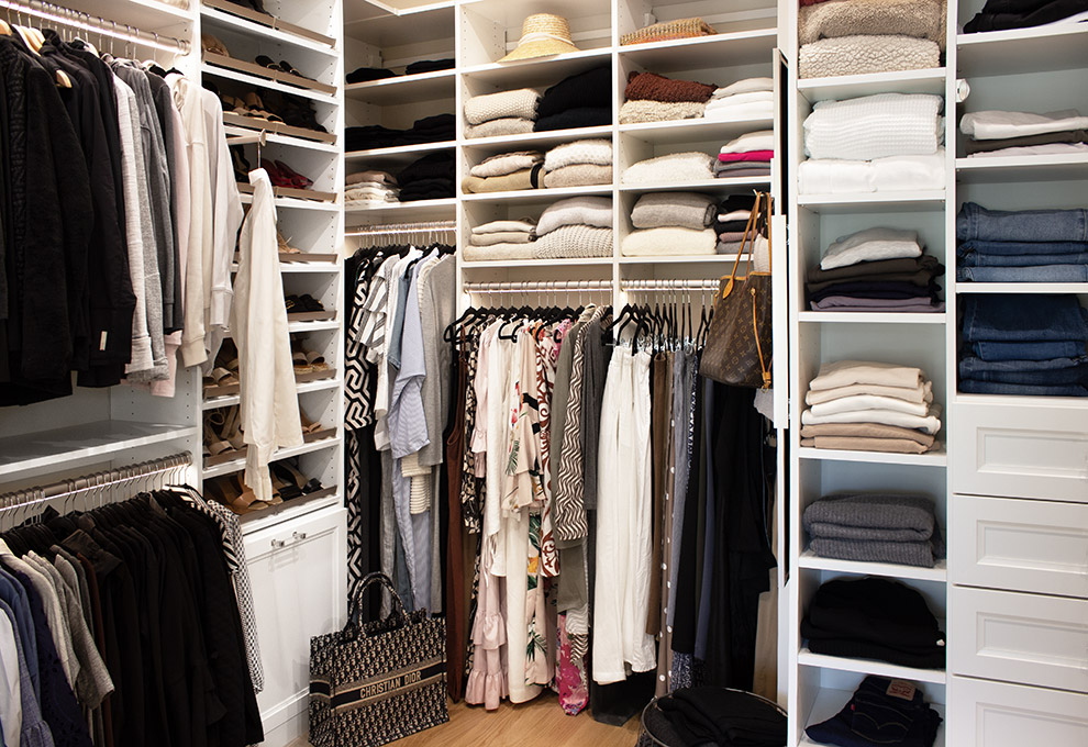 Spacious Organized White Closet with Angled Shoe Shelves and Shoe Cubbies and Lighted Garment Rods