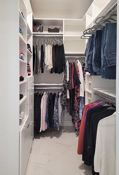 Ladies Walk-In Closet with Abundant Hanging Space, Cabinet Drawers and Open Shelving