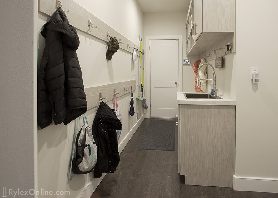 Mudroom with Expansive Wall Organizes Mops, Coats Back Packs with Hooks