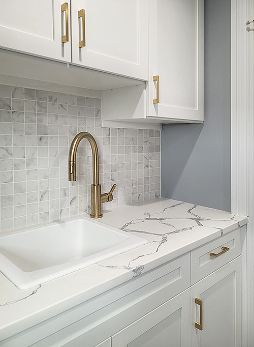 Close On White Laundry Cabinets with Gold Hardware