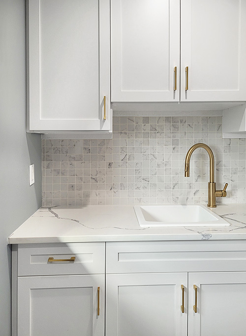 Laundry Room Sink with Upper and Lower White Cabinets