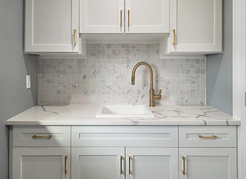 White Laundry Cabinets with Gold Hardware